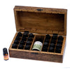 A rustic carved mango wood aromatherapy box with hinged lid holding black-capped essential oils in compartments