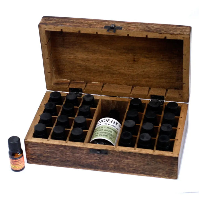 A rustic carved mango wood aromatherapy box with hinged lid holding black-capped essential oils in compartments