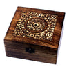 A dark brown mango wood aromatherapy box with floral carvings and a black metal clasp holds essential oils