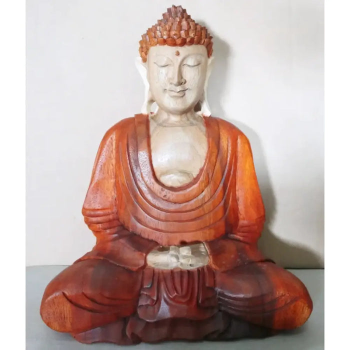 Carved wood buddha statue in suar wood with smooth light face and warm reddish brown robe for meditation 30cm tall