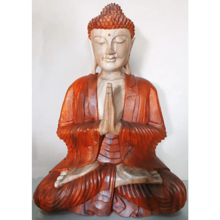 A carved wood buddha statue in suar wood with a reddish-brown robe seated in meditation 60cm tall