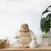 Hand-carved happy buddha statue in light beige suar wood with natural grain and whitewash robes 30cm tall