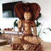 Carved wood shiva statue with cobra hood and beaded necklaces made from suar wood in natural brown tones seated