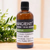 A 100 ml amber glass bottle of organic castor base oil from india with a black ribbed cap and label