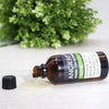 A dark amber glass bottle of castor organic base oil 100ml with a black screw cap and organic origin label