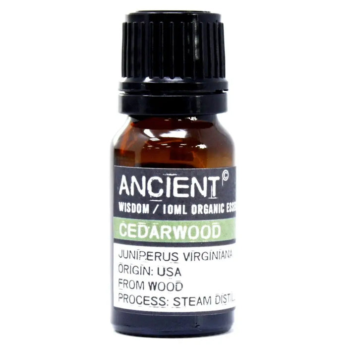A small amber glass bottle of cedarwood organic essential oil with a black cap and allergen declarations label