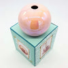 A glossy peach ceramic ball reed diffuser vase with a subtle iridescent sheen and a hole at the top