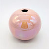 A glossy pink ceramic ball reed diffuser vase with a smooth spherical shape and a hole at the top