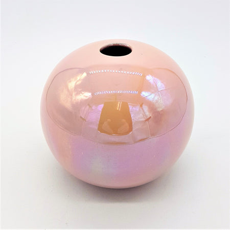 A glossy pink ceramic ball reed diffuser vase with a smooth spherical shape and a hole at the top