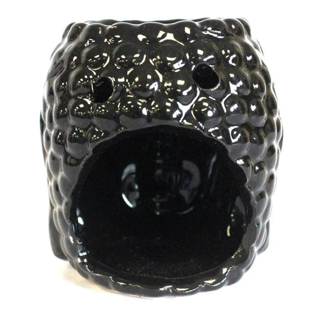 Black ceramic oil burner with textured bumpy surface and two small holes on top for oil burners use