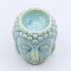 A light blue ceramic buddha head oil burner with detailed facial features and a glossy finish for incense or oils