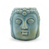 A serene pastel blue ceramic oil burner shaped like a detailed buddha head with a textured bead crown