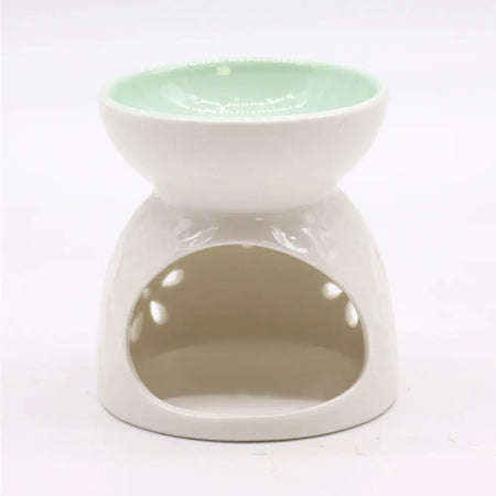 White ceramic oil burner with teal interior and floral cut-out patterns for aromatherapy use