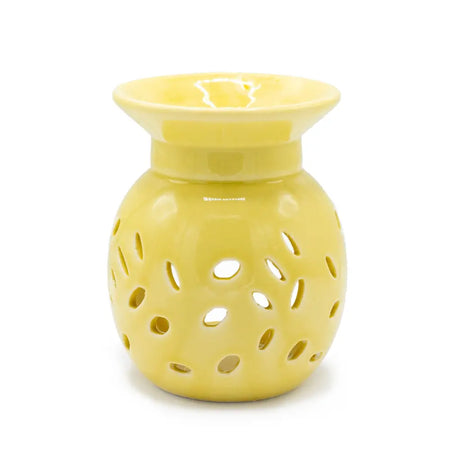 A yellow ceramic oil burner with a flared rim and decorative perforated floral body for aromatherapy use