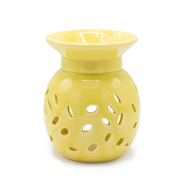 A yellow ceramic oil burner with a flared rim and decorative perforated floral body for aromatherapy use