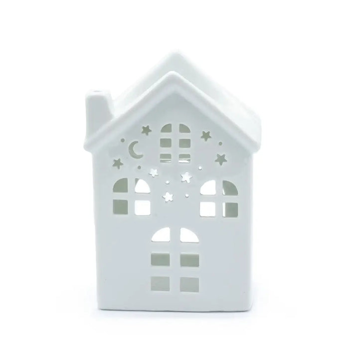 White ceramic oil burner shaped like a house with cut-out star and moon patterns for house-warming decor