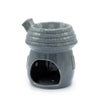 Gray ceramic oil burner shaped like a mushroom house with brick-textured roof and chimney for oil burners use