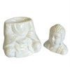 White ceramic oil burner with seated buddha head figurine designed as a decorative oil burner piece