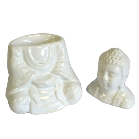 White ceramic oil burner with seated buddha head figurine designed as a decorative oil burner piece
