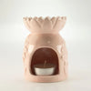 Pink ceramic sunflower oil burner shaped like a lotus with a tealight candle inside its arched opening