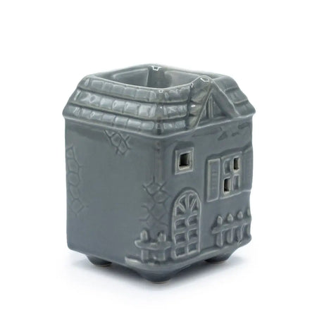 Gray ceramic oil burner shaped like a house with detailed windows roof and door design for oil diffusion