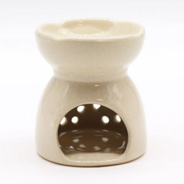 Cream-colored ceramic oil burner with flower-shaped top and circular cutouts for aroma diffusion in ivory finish
