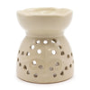 Cream-colored ceramic oil burner with fluted rim and tree of life design on decorative perforated base