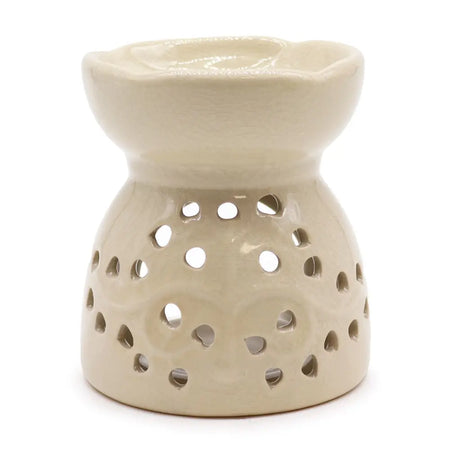 Cream-colored ceramic oil burner with fluted rim and tree of life design on decorative perforated base