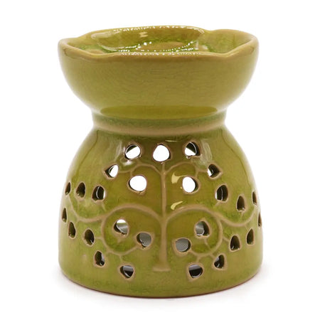 A lime green ceramic oil burner with tree of life pattern and circular cutouts for essential oils