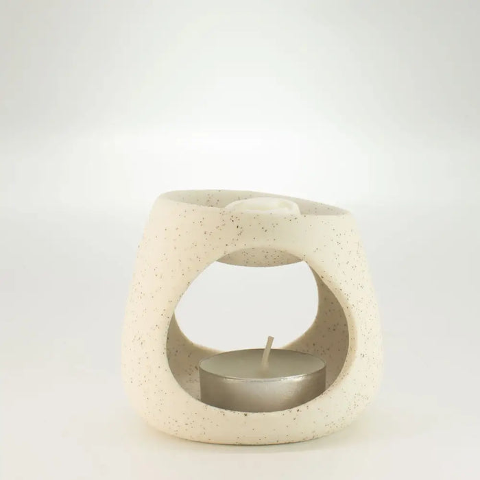 Cream-colored speckled ceramic zen pebble oil burner with circular opening and built-in tea light holder in off-white