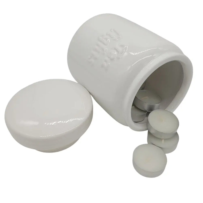 White ceramic storage jar with embossed text holding small silver tea light candles and wax melts