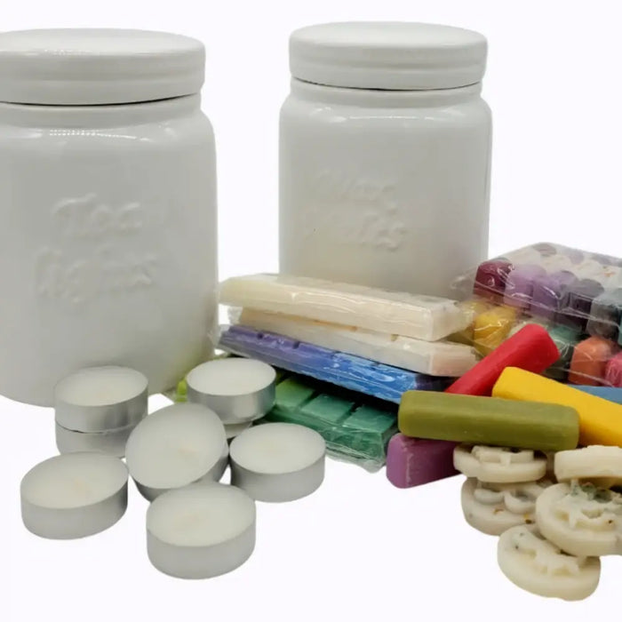 White ceramic storage jars with embossed text sit beside colorful wax melts and tealight candles