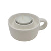 White ceramic candle holder shaped like a coffee cup with a small white tealight candle inside