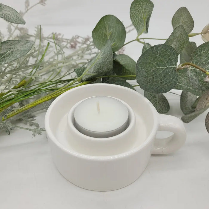 White ceramic candle holder with a silver tealight candle inside for use as a tealight and dinner candle holder