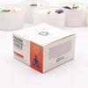 White cardboard box for root chakra crystal candle with orange and black design and meditating figure silhouette