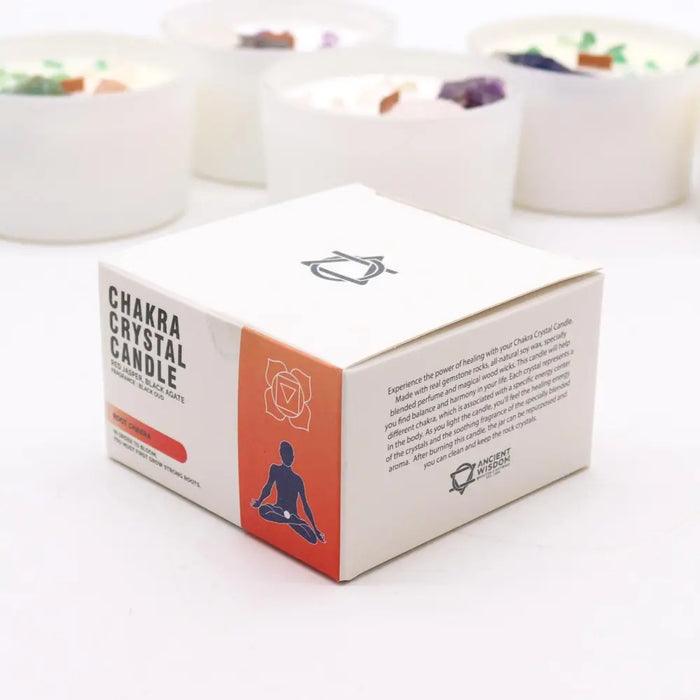 White cardboard box for root chakra crystal candle with orange and black design and meditating figure silhouette