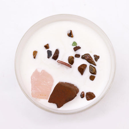 A white candle with colorful polished gemstones embedded in wax for sacral chakra creative passion use