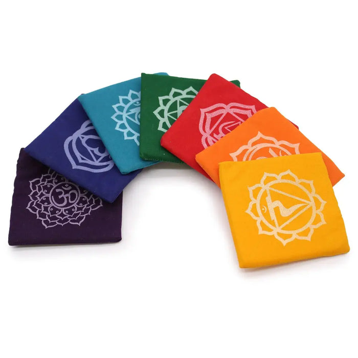 Set of seven colorful fabric pouches with white embroidered chakra symbols for chakra singing bowl gift set