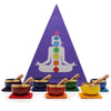 Set of seven colorful chakra singing bowls with wooden mallets on matching mats in a chakra singing bowl gift set