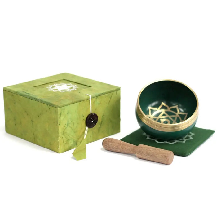 Green chakra singing bowl with gold heart chakra design and gold rim in a green marbled box