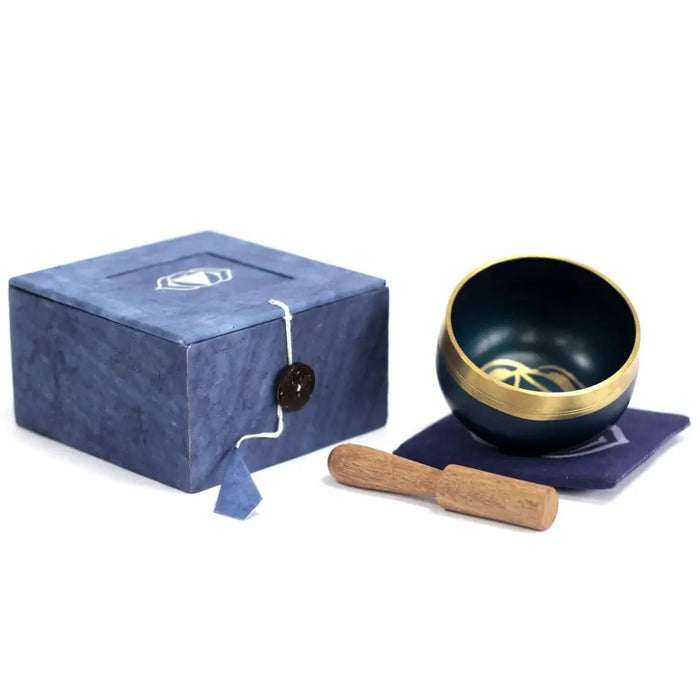 Dark blue chakra singing bowl with gold rim and intricate design for third eye chakra with wooden mallet