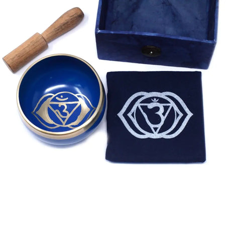 Deep blue chakra singing bowl with gold rim and silver om symbol for the third eye chakra meditation and healing