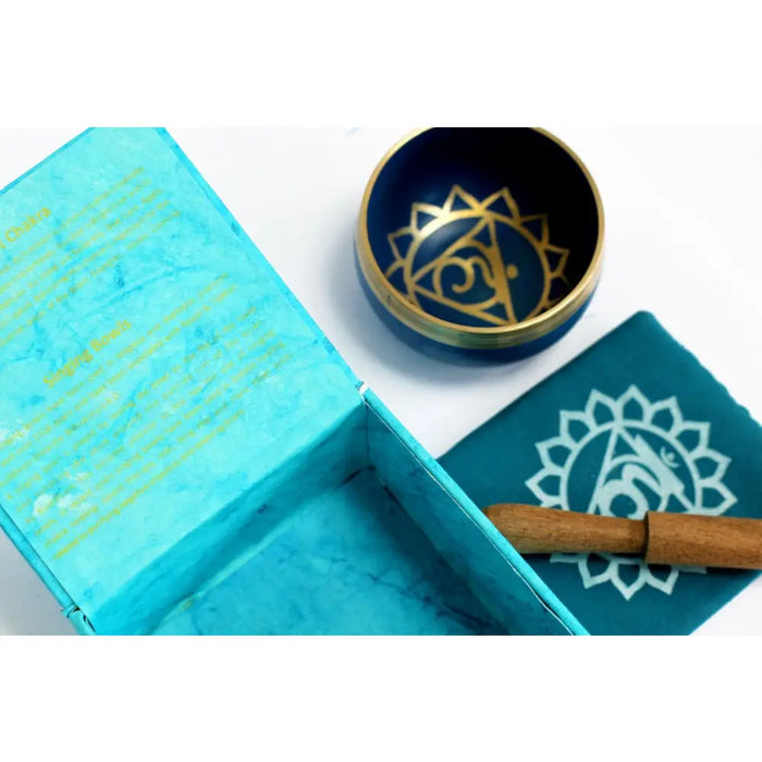 Blue brass chakra singing bowl with gold throat chakra symbol design for chakra singing and meditation