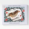 A christmas card pack featuring a brown song thrush on branches with red berries in a snowy starry background