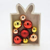 A collection of shiny red gold and rose gold metallic christmas baubles in a white wooden gift box with two designs