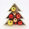 A rustic white wooden christmas baubles ornament holder filled with shiny red and gold baubles in two designs