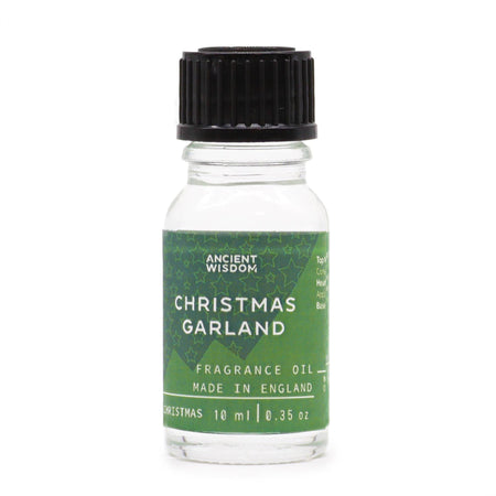A clear glass bottle with black ribbed cap and green label of christmas garland fragrance oil with allergen declarations