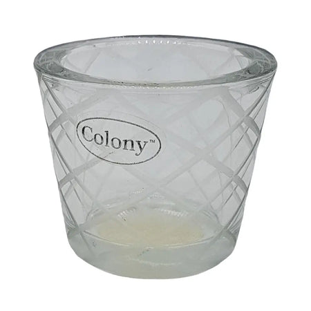 Chunky glass tealight holder with clear diamond-cut pattern and oval colony logo etched on the side