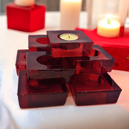 Stacked translucent red glass tealight holders with square design and circular cutouts for tealight candles