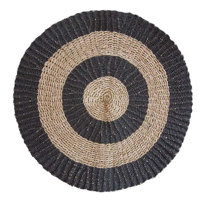 Circular seagrass rug with dark gray and natural beige concentric rings made from textured fiber material